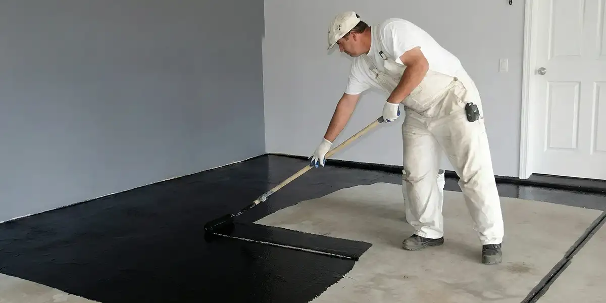 basement waterproofing professional applying waterproof coating to protect a basement floor in Lakeland, FL